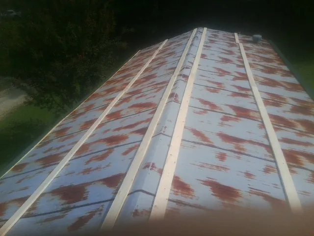 Rusted metal roof panels with new wood purlins before replacement — Storm Damage Roof Repair in Coolidge by Roofing Brothers