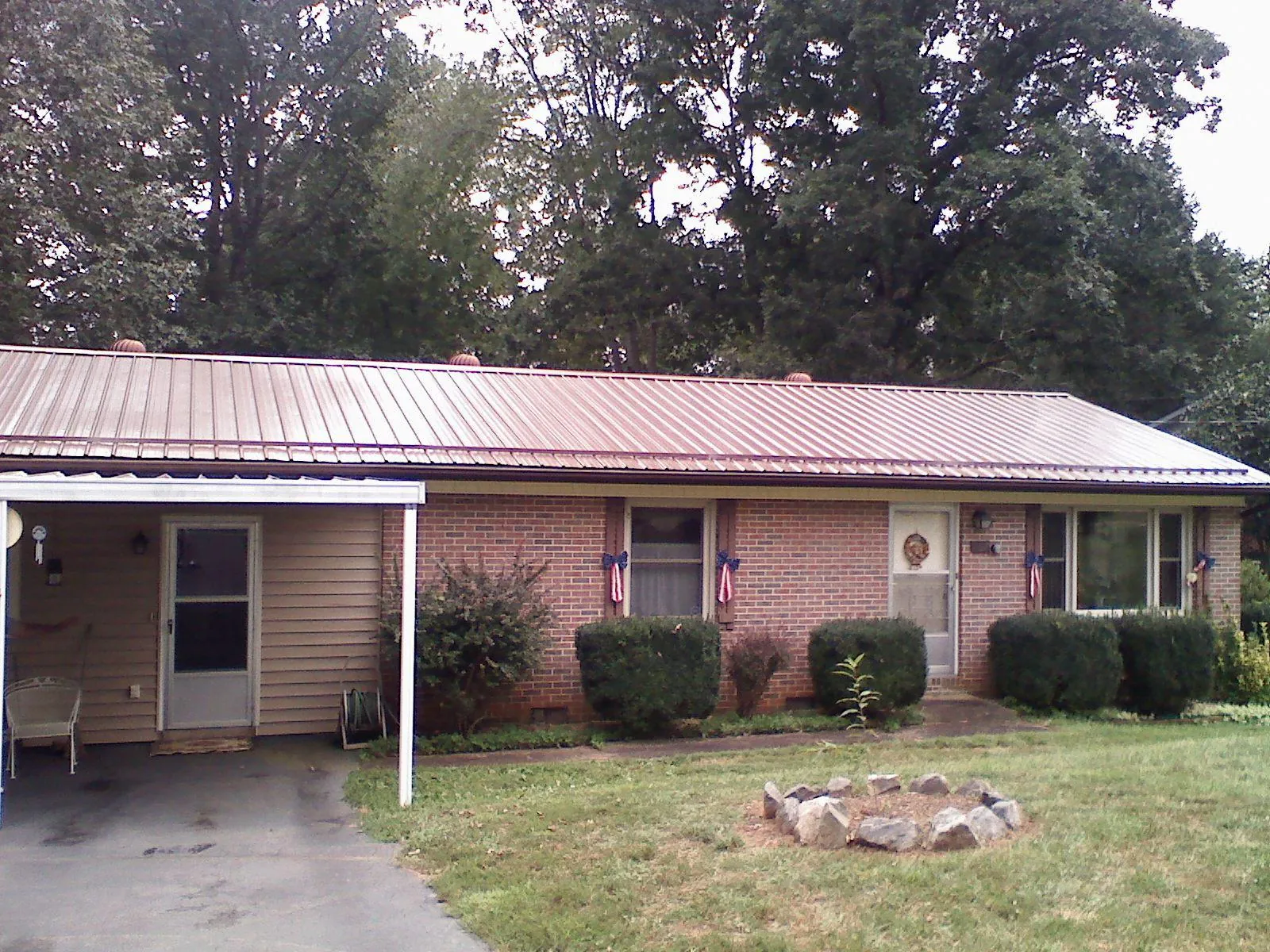 Bronze metal roof and carport on a brick ranch home — Roof Repair work by our crew in Coolidge